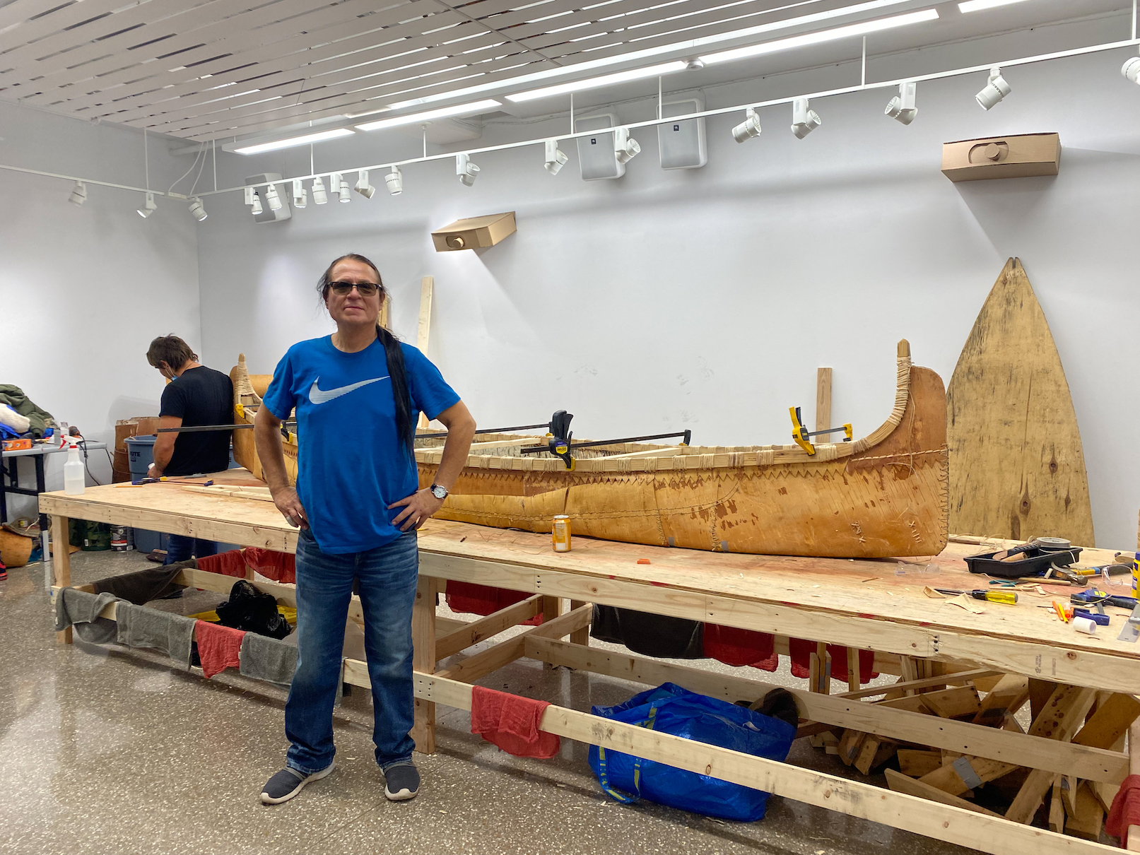 Valliere stands in front of the unfinished canoe.